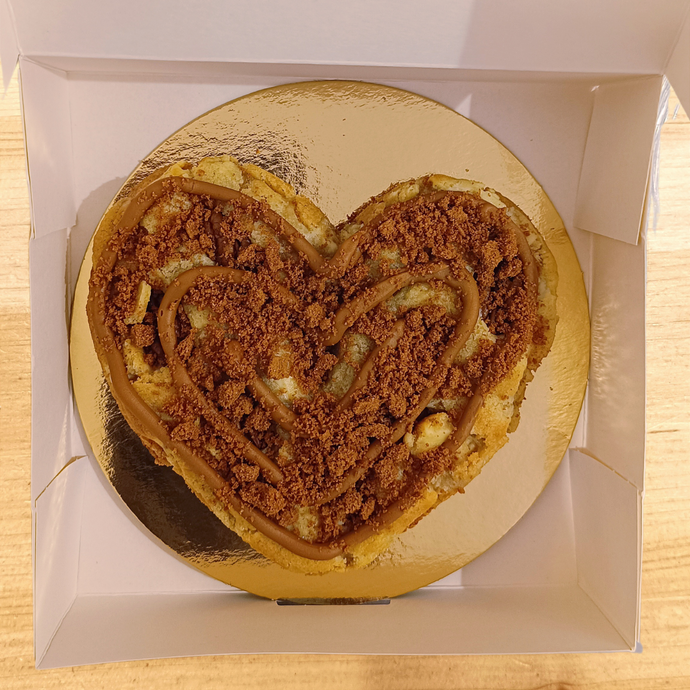 Un grand cookie en forme de coeur à partager avec des nappages et toppings ultra gourmands